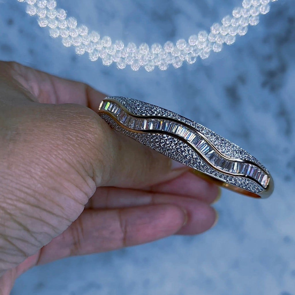 Costosa Diamond Baguette Bangle Bracelet Impeccable craftmanship and quality! You'll have this bracelet for years and it will still look the same as the day you bought it. 2 1/2" in diameter at it's widest point. Bangle has a clasp closure that can be opened and snapped closed securely to fit most sized wrists. Water and tarnish resistant, 18k gold plated, CZ crystal, baguette and pave stones.